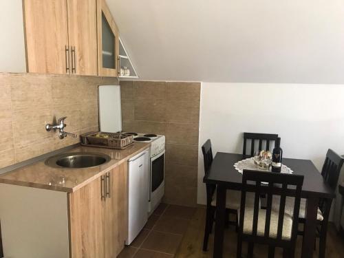 a kitchen with a sink and a table with chairs at Mountain House Tara Apartmani Nikolic in Kaludjerske Bare