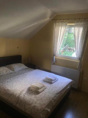 a bedroom with a bed with two towels on it at Mountain House Tara Apartmani Nikolic in Kaludjerske Bare