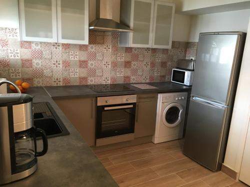 une cuisine avec un réfrigérateur et une machine à laver dans l'établissement Charmant duplex aux portes de Paris, à Bagneux