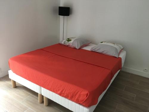a bed in a room with a red blanket at Charmant duplex aux portes de Paris in Bagneux