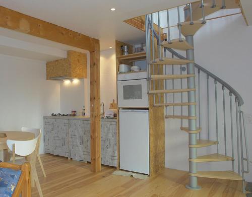 - une cuisine avec un escalier en colimaçon dans une pièce dans l'établissement leKarl, à Queyrières