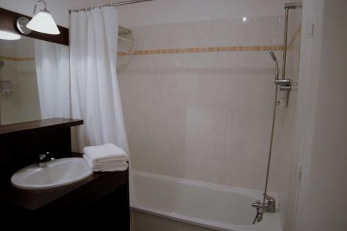 a bathroom with a sink and a shower with a shower curtain at NEW- Relaxing studio - 5 min from Disneyland Paris in Montévrain