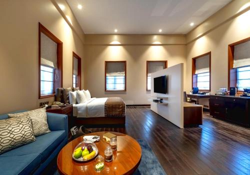 a hotel room with a bed and a living room at Kenilworth Hotel, Kolkata in Kolkata