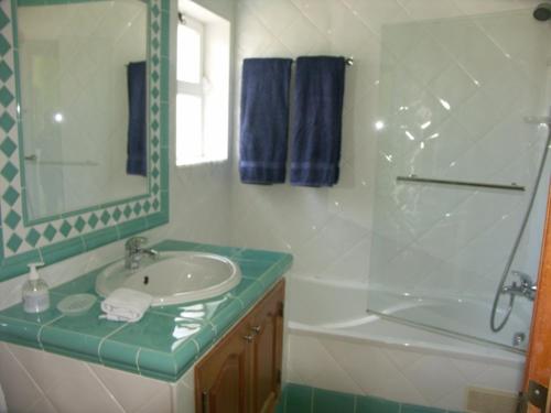 a bathroom with a sink and a tub and a mirror at 12 A Clube Golfemar in Carvoeiro