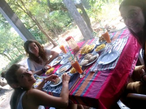 un grupo de personas sentadas en una mesa comiendo comida en Dambulla Sun Vsh Holiday, en Dambulla