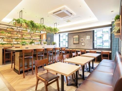 a restaurant with tables and chairs and books at Super Hotel Tottori Ekimae in Tottori