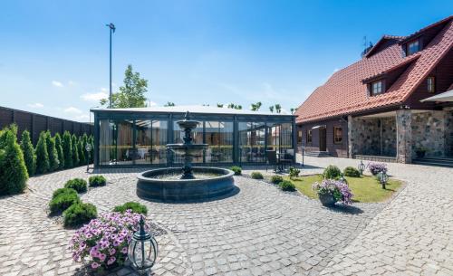 a courtyard with a fountain in front of a building at Hotel - Bar Grafaite in Šiauliai