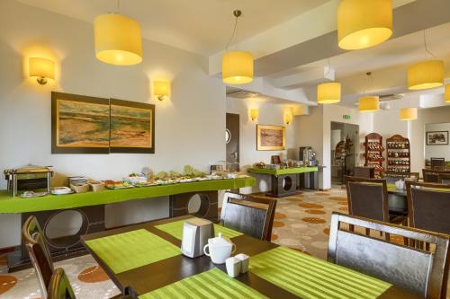 a restaurant with tables and chairs and yellow lights at 4 Pory Roku & Spa in Krynica Zdrój