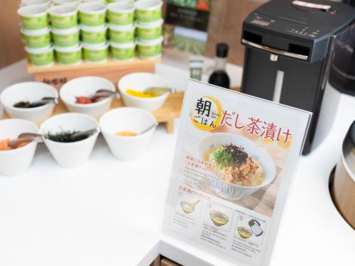 a sign on a counter with bowls of food at Super Hotel Tottori Ekimae in Tottori
