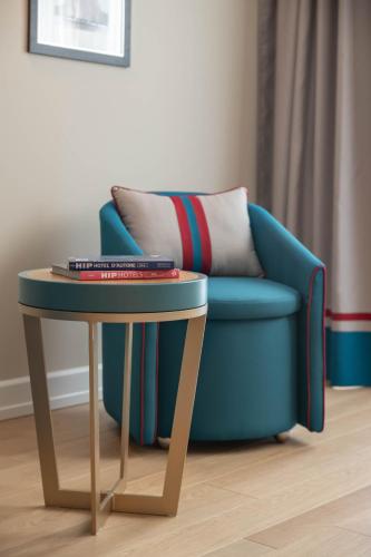 a blue chair sitting next to a table with a pillow at Grand Hotel & Riviera in Lido di Camaiore