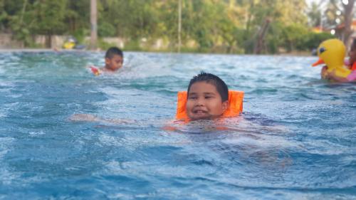 two young children swimming in a swimming pool at Moonshine Resort Chumphon in Chumphon