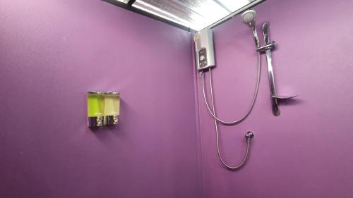 a purple bathroom with a shower with a shower head at Moonshine Resort Chumphon in Chumphon