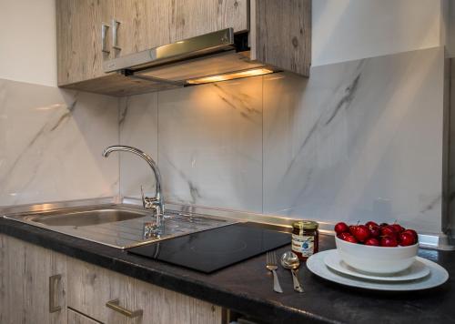 a kitchen counter with a sink and a bowl of apples at Mr & Mrs K Lofts in Potos