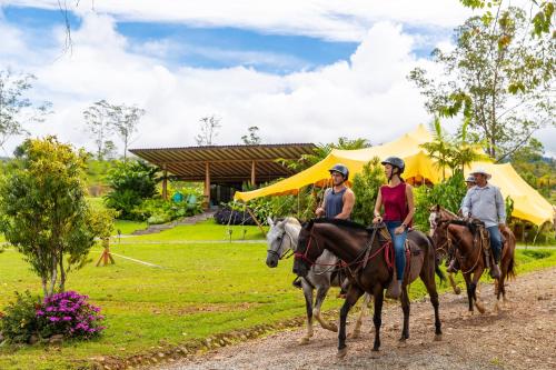 a group of people riding horses on a dirt road at Kinkara Luxury Retreat in San Isidro