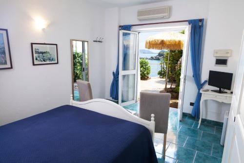 um quarto com uma cama, uma secretária e uma janela em O' Vagnitiello - Parco Balneare Idroterapico - Camere - Ristorante em Ischia