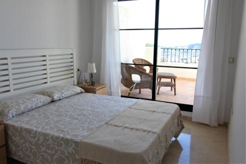 1 dormitorio con cama y vistas a un balcón en El Balcón de Sierra Cortina 4, en Finestrat