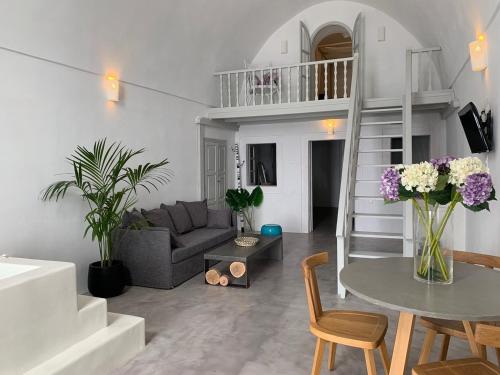 a living room with a couch and a table with flowers at Imer Villas in Imerovigli