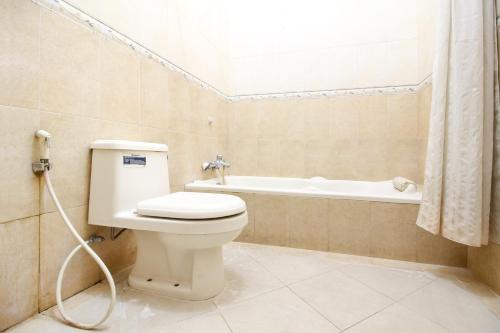 ジョグジャカルタにあるRedDoorz plus @ Tegal Panggungのトイレと浴槽付きのバスルーム