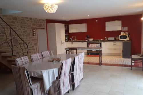 une cuisine avec une table et des chaises avec un chat. dans l'établissement TY MIALY, à Erdeven