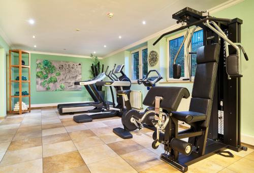 a gym with treadmills and cardio equipment in a house at Garden & SPA Hotel Das Götzfried in Regensburg