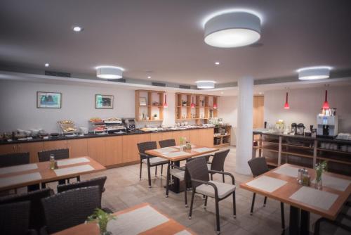 a restaurant with tables and chairs and a kitchen at Lobogo Resort in Vlăhiţa