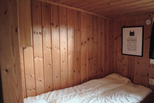 a bedroom with a bed in a wooden wall at Backens Fjällboende in Tännäs