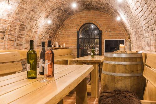 a wine tasting room with wine bottles on a wooden table at Vinoza - ubytování a vinný sklep v Moravském Toskánsku in Hovorany