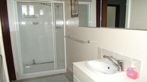 a bathroom with a glass shower and a sink at Don't Worry Be Happy in Jurien Bay