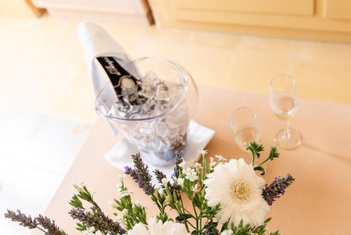 a table with wine glasses and a bouquet of flowers at Relais Masseria Villa Cenci in Cisternino