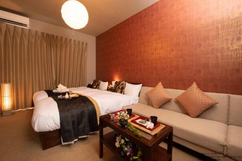 a living room with a couch and a bed at Stay SAKURA Kyoto Fuga in Kyoto