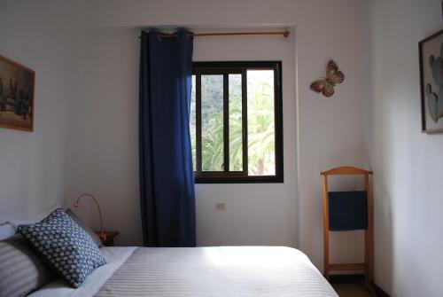 a bedroom with a bed and a window with a butterfly at Hostal Casa Amaya in Vallehermoso
