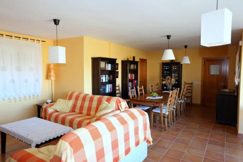 een woonkamer met een bank en een eetkamer bij Casa Rural La Casa de la Herrería in Vega del Cadorno