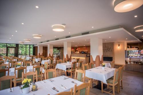 a dining room with white tables and chairs at Lobogo Resort in Vlăhiţa