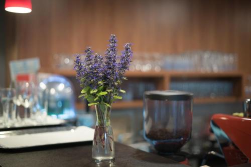 a vase filled with purple flowers sitting on a table at Lobogo Resort in Vlăhiţa