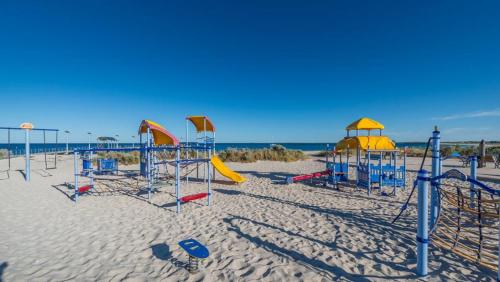 a playground on a sandy beach near the ocean at Don't Worry Be Happy in Jurien Bay