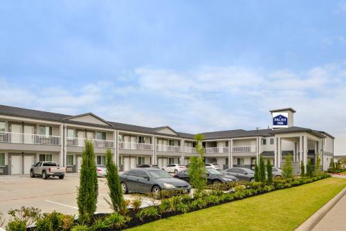 a hotel with cars parked in a parking lot at Palace Inn Blue Tomball Parkway in Houston