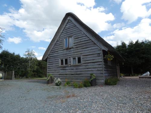 a small house with a gambrel roof at Yew Tree Barn in Prees