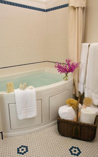 a bathroom with a tub with a vase of flowers at Lake Pointe Inn in McHenry