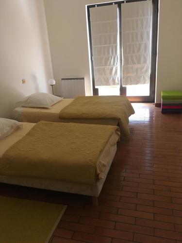 deux lits assis dans une pièce avec une fenêtre dans l'établissement Le XIII, à Hoenheim