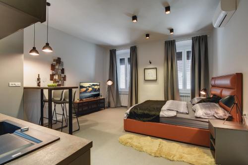 a bedroom with a large bed and a kitchen at APARTMENTS NOVAK in Pula