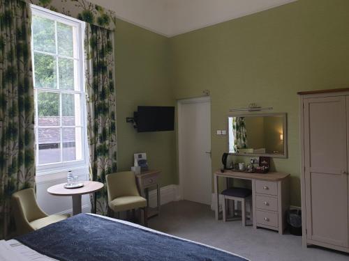 a bedroom with a bed and a table and a mirror at The Osborne Hotel in Torquay