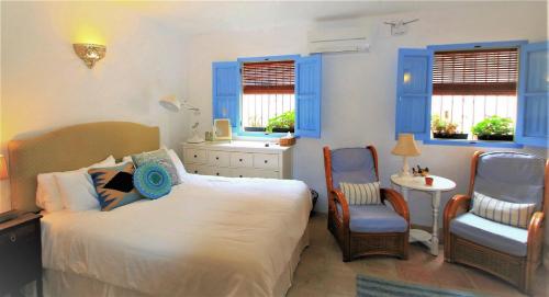 Pinos del Valle的住宿－Casa del Patio，卧室配有一张床和一张桌子及椅子