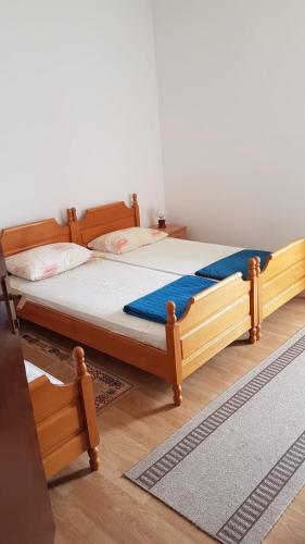 a wooden bed in a room with at Apartmani AnĐela in Neum