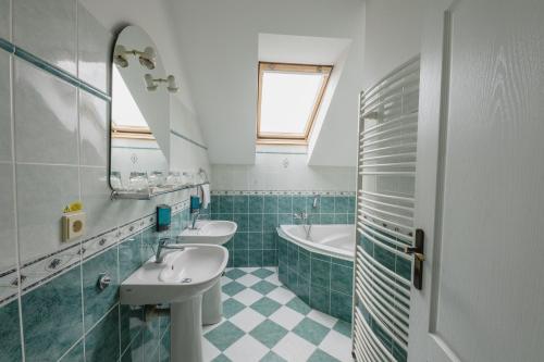 a bathroom with two sinks and a bath tub at Hotel Taverna in Javorník