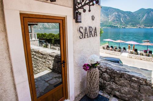 a door to a restaurant with a view of the ocean at Hotel Sara in Kotor