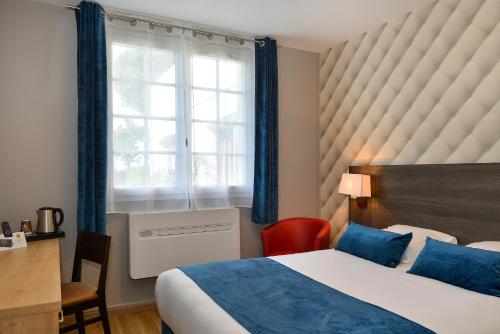 A bed or beds in a room at Logis Hôtel Restaurant des Châteaux