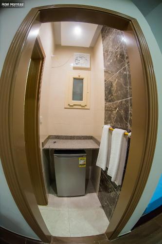 a bathroom with a circular mirror in a room at El Mena Beach in Ras El Bar