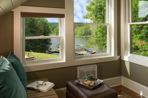 a living room with three windows and a bowl of fruit at Lake Pointe Inn in McHenry