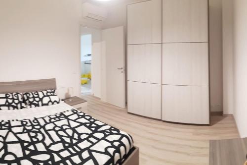 a bedroom with a black and white bed and a cabinet at Appartamento Sette Lecci in Lido di Camaiore