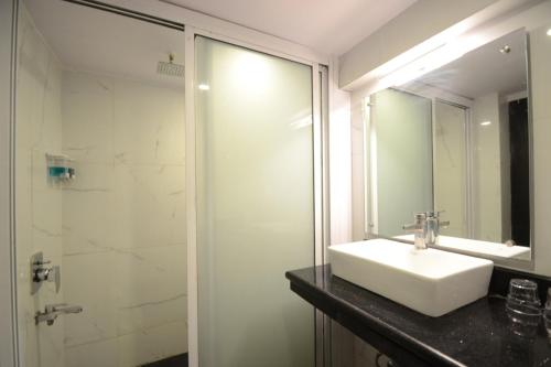 bagno con lavandino e doccia con specchio di Hotel Kapish Smart-All Pure Veg a Jaipur